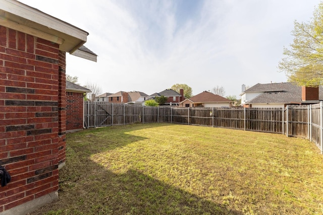 view of yard featuring a fenced backyard and a residential view