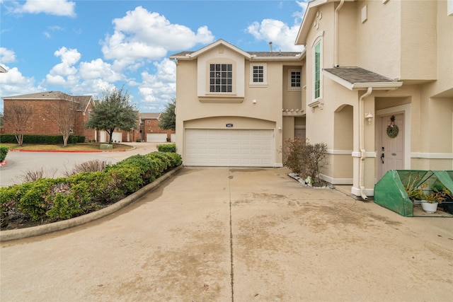 view of front of house with concrete driveway, an attached garage, and stucco siding