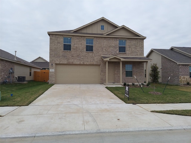 view of front of house with a garage, a front yard, and central air condition unit