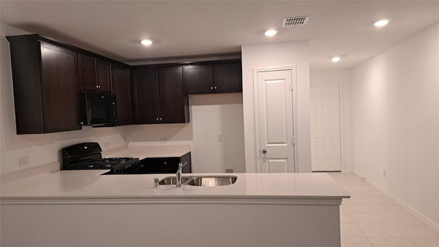 kitchen with sink, kitchen peninsula, dark brown cabinetry, and black appliances