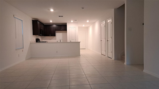 interior space with sink, light tile patterned floors, and kitchen peninsula