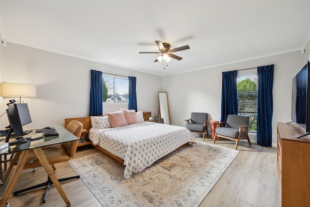 bedroom with crown molding, ceiling fan, and light hardwood / wood-style flooring