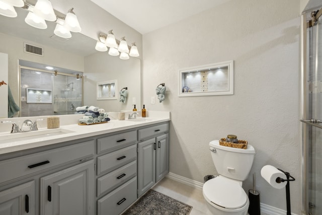 bathroom with vanity, a shower with shower door, and toilet