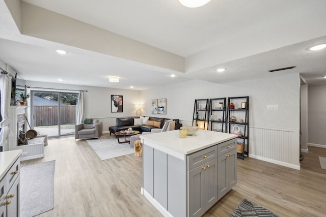 kitchen featuring gray cabinets, a kitchen island, and light hardwood / wood-style floors