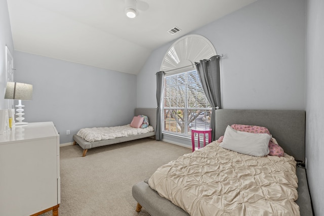 carpeted bedroom with visible vents, vaulted ceiling, and baseboards