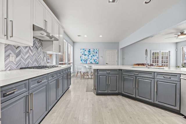 kitchen with under cabinet range hood, white cabinetry, appliances with stainless steel finishes, and gray cabinetry