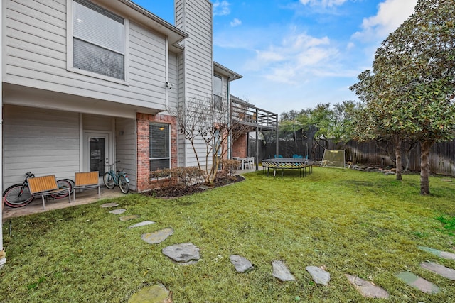 view of yard with a patio, a trampoline, and a fenced backyard