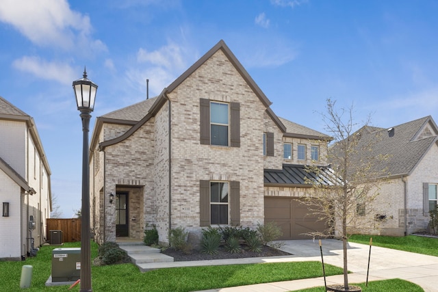 view of front of home featuring central AC unit, a garage, and a front lawn