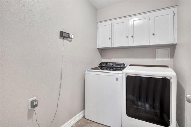 laundry area with washing machine and dryer and cabinets