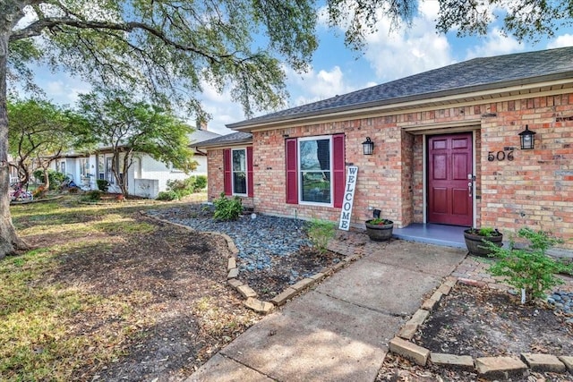 single story home with a shingled roof and brick siding