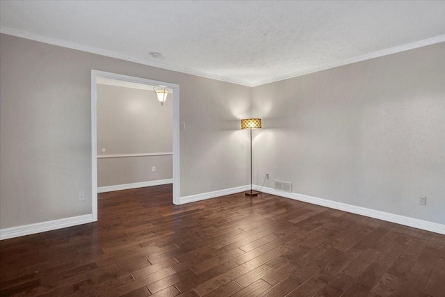 empty room featuring dark hardwood / wood-style flooring and crown molding