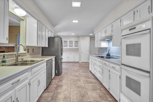 kitchen with white cabinetry, stainless steel appliances, sink, and light tile patterned floors