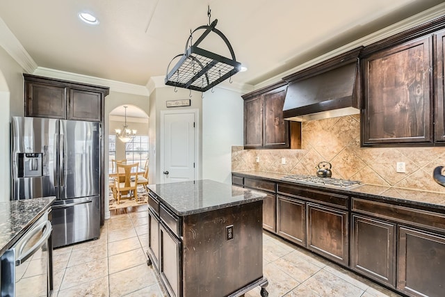 kitchen with stainless steel appliances, crown molding, dark brown cabinets, and wall chimney exhaust hood