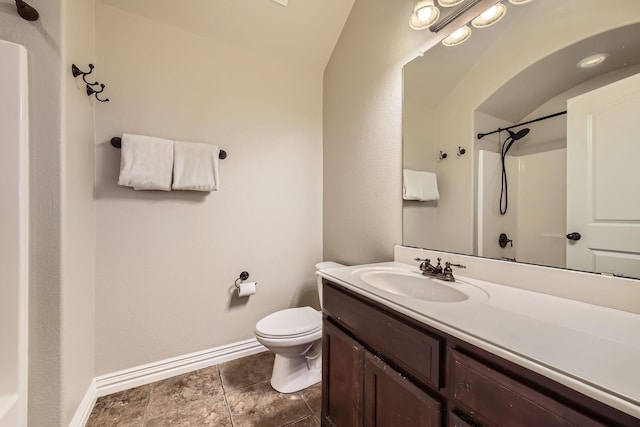 bathroom with vanity, vaulted ceiling, a shower, and toilet