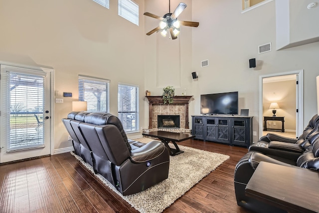 living room featuring dark hardwood / wood-style flooring, a fireplace, and ceiling fan