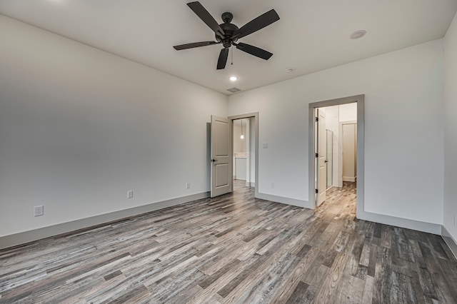 unfurnished bedroom with ceiling fan, visible vents, baseboards, and wood finished floors