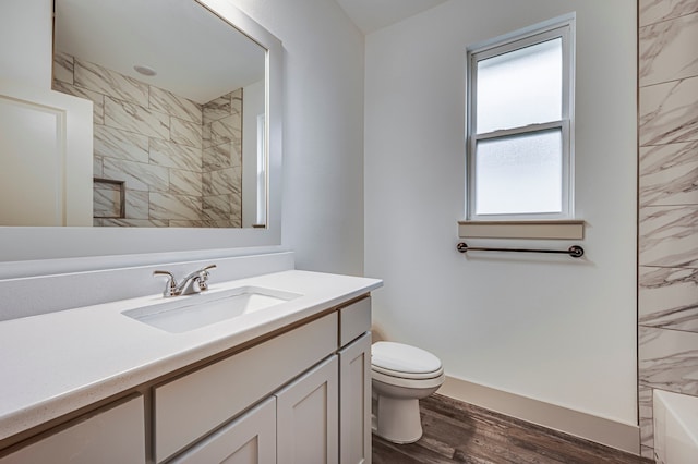 bathroom with toilet, a bathing tub, wood finished floors, vanity, and a shower