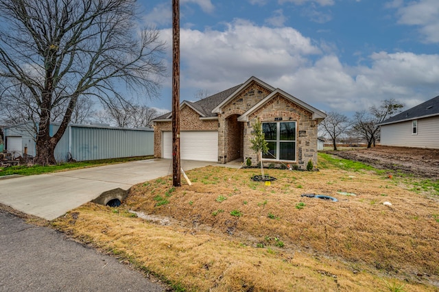 view of front of property featuring brick siding, stone siding, concrete driveway, and a garage
