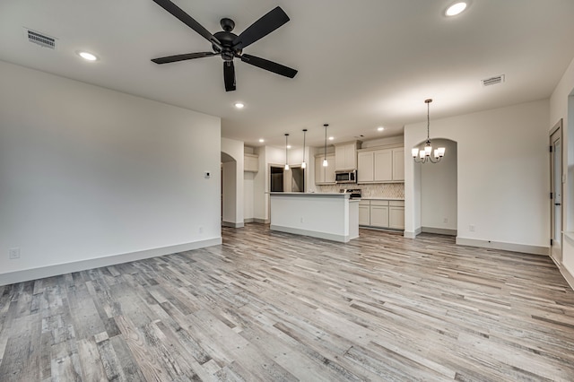 unfurnished living room featuring visible vents, light wood-type flooring, ceiling fan with notable chandelier, recessed lighting, and baseboards