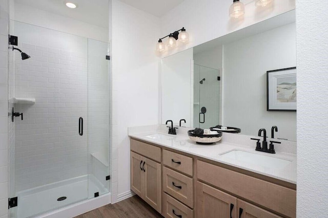 bathroom with wood-type flooring, vanity, and a shower with shower door