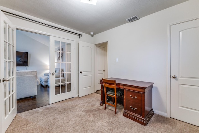 office featuring light colored carpet, french doors, and a textured ceiling