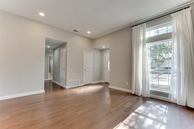 spare room with baseboards, visible vents, wood finished floors, and recessed lighting