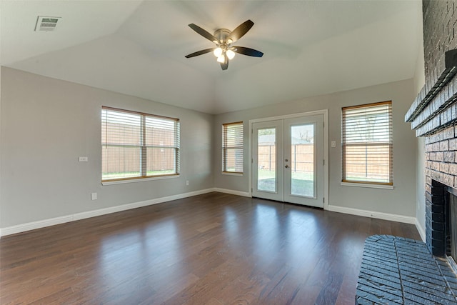 unfurnished living room featuring a wealth of natural light, dark wood-type flooring, a ceiling fan, and a brick fireplace