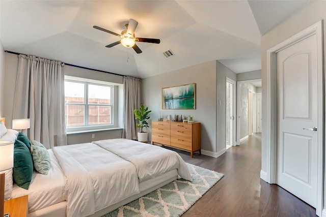 bedroom featuring dark wood-style floors, a ceiling fan, visible vents, vaulted ceiling, and baseboards