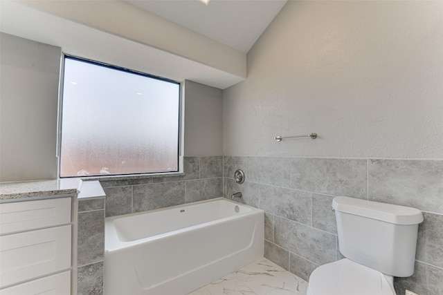 bathroom featuring vanity, toilet, tile walls, and a washtub