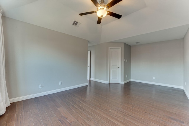 empty room with wood finished floors, ceiling fan, baseboards, visible vents, and lofted ceiling
