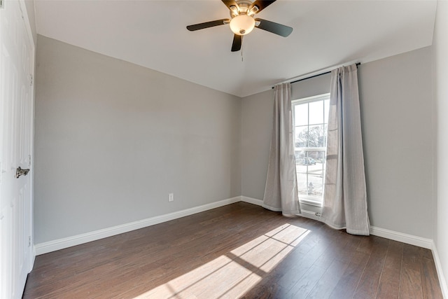 empty room featuring hardwood / wood-style flooring, a ceiling fan, and baseboards