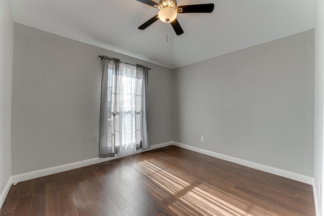 empty room with baseboards, ceiling fan, and dark wood-style floors