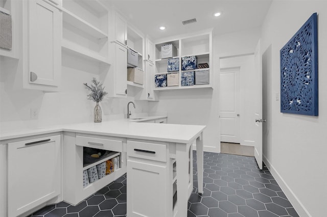 kitchen featuring white cabinetry, dark tile patterned flooring, sink, and kitchen peninsula