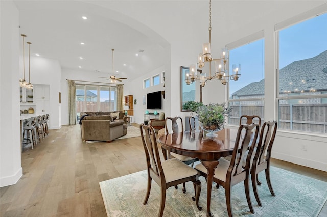 dining space featuring ceiling fan with notable chandelier and light hardwood / wood-style flooring