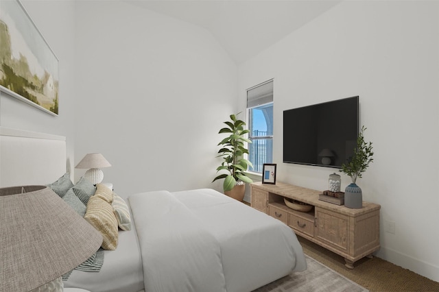 bedroom featuring lofted ceiling and light colored carpet