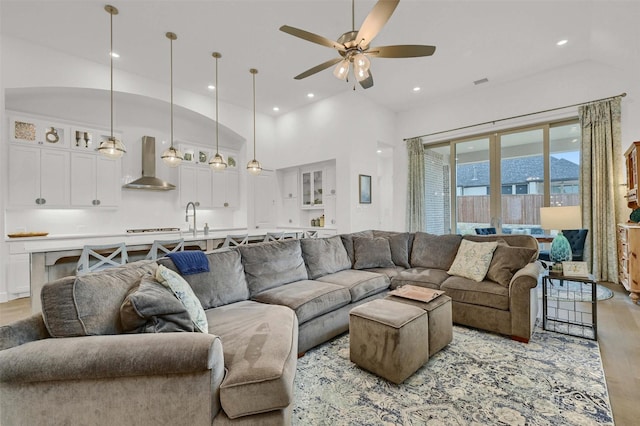 living room with ceiling fan, sink, and a high ceiling