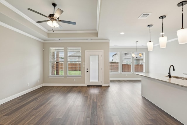 unfurnished living room featuring crown molding, visible vents, a sink, and ceiling fan with notable chandelier
