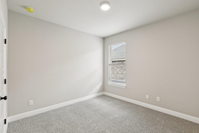 carpeted spare room with baseboards
