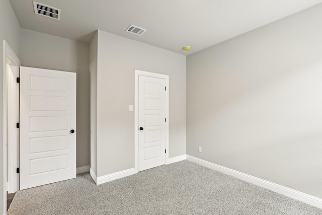 unfurnished bedroom with carpet flooring, baseboards, and visible vents
