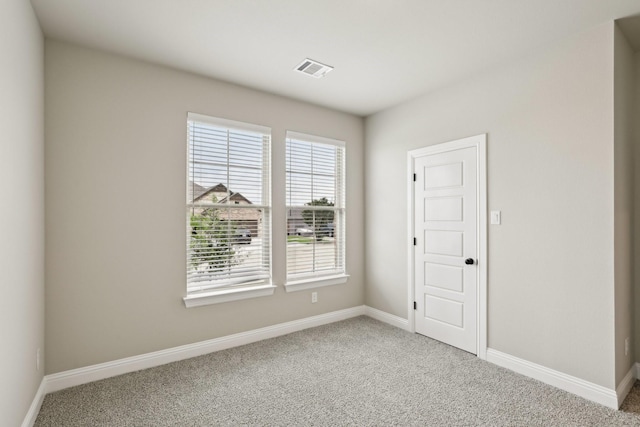 unfurnished room featuring baseboards, carpet flooring, and visible vents