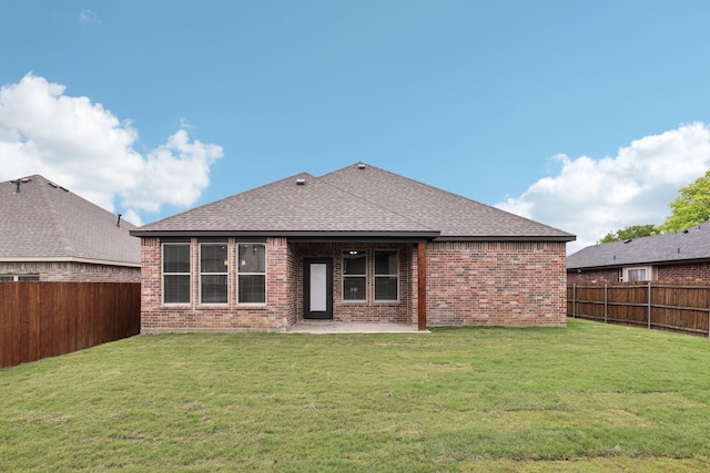 back of house featuring a fenced backyard, a patio area, roof with shingles, and brick siding