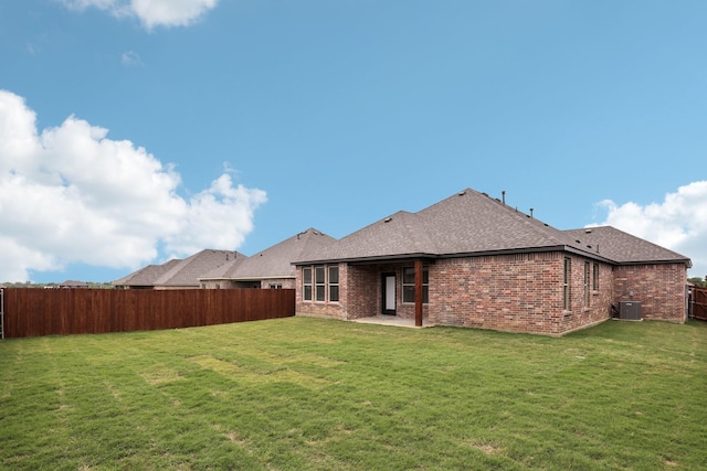 back of house featuring a lawn and fence