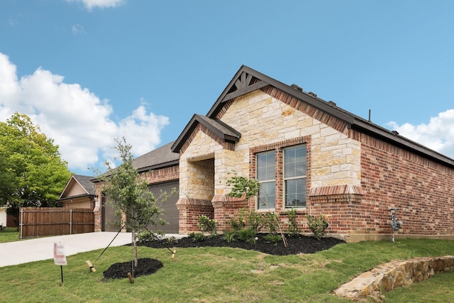 view of front of property with fence, driveway, a front lawn, and a garage