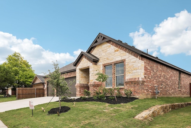 view of front of home featuring fence, an attached garage, stone siding, a front yard, and concrete driveway