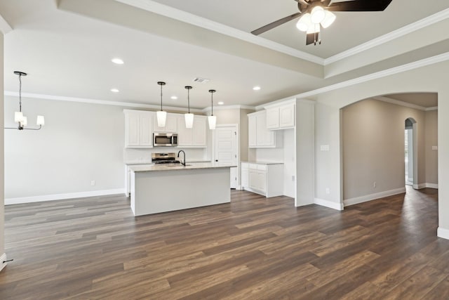unfurnished living room with arched walkways, ceiling fan with notable chandelier, recessed lighting, baseboards, and dark wood-style floors