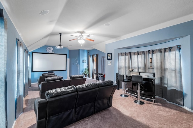 carpeted cinema room with ceiling fan and vaulted ceiling