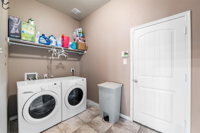 clothes washing area with washing machine and dryer and light tile patterned floors