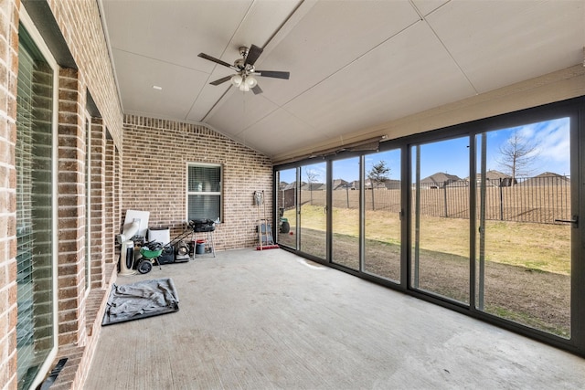 unfurnished sunroom featuring ceiling fan and vaulted ceiling