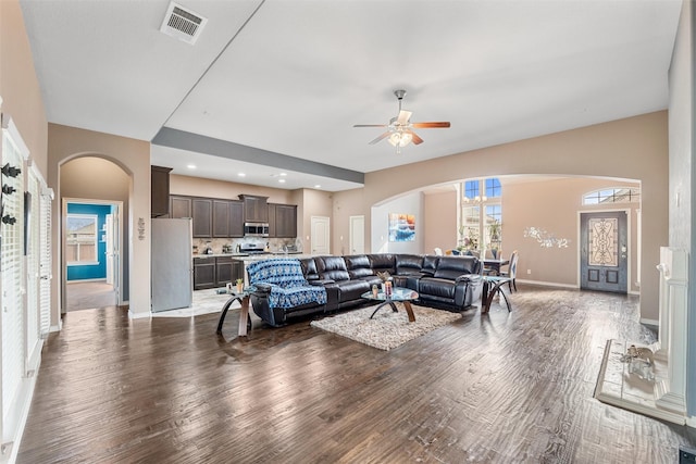 living room featuring dark wood-type flooring and ceiling fan