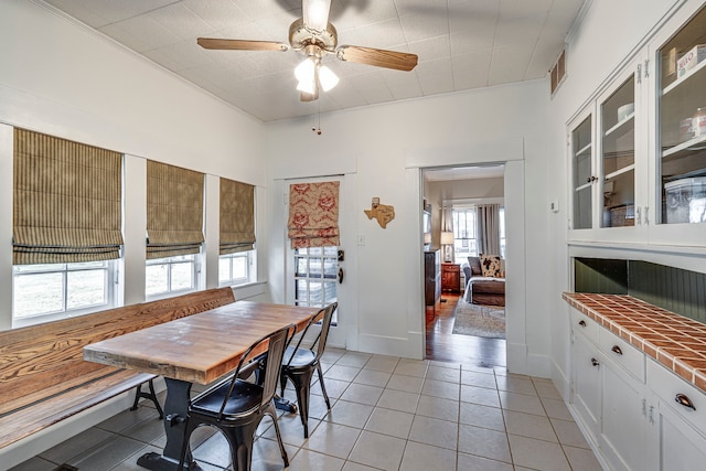 tiled dining space with ceiling fan